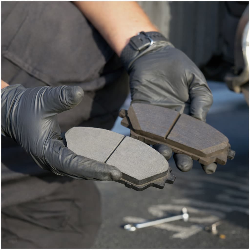 Mekanik Eldivenli Bir Teknisyenin Elinde Yeni Ve Aşınmış Fren Balatalarının Karşılaştırılması